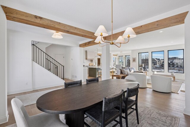 10154 Peony Ln N, Maple Grove, MN 55311 - dining room featuring a chandelier, wood finished floors, stairs, beamed ceiling, and baseboards