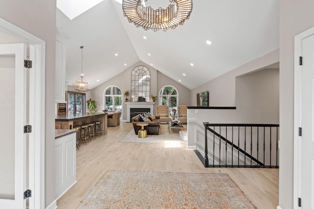 6141 Sherman Cir, Edina, MN 55436 - hallway with light wood-style floors, recessed lighting, high vaulted ceiling, stairs, and a chandelier