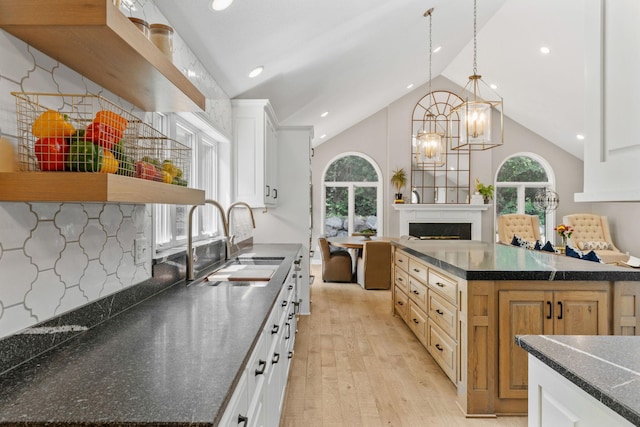 6141 Sherman Cir, Edina, MN 55436 - kitchen with light wood-style floors, open shelves, a fireplace, a chandelier, and high vaulted ceiling