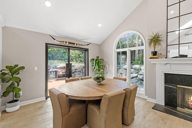 6141 Sherman Cir, Edina, MN 55436 - dining area featuring light wood finished floors, a premium fireplace, plenty of natural light, high vaulted ceiling, and recessed lighting