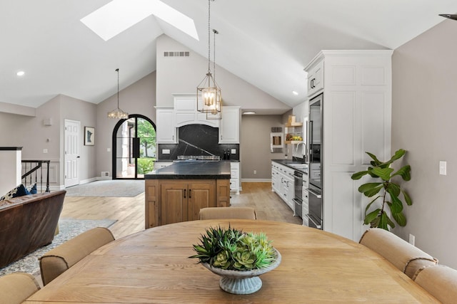 6141 Sherman Cir, Edina, MN 55436 - dining space featuring light wood-style flooring, high vaulted ceiling, a skylight, and recessed lighting