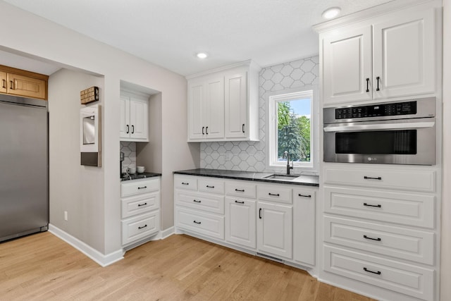 6141 Sherman Cir, Edina, MN 55436 - kitchen with appliances with stainless steel finishes, light wood-style flooring, decorative backsplash, and recessed lighting