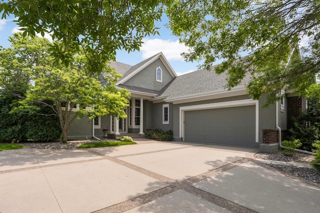 1540 Waterford Ct, Golden Valley, MN 55422 - view of front of house with stucco siding, an attached garage, a shingled roof, and driveway