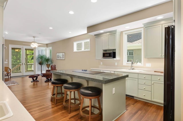 1540 Waterford Ct, Golden Valley, MN 55422 - kitchen featuring a sink, freestanding refrigerator, a kitchen bar, dark wood-style flooring, and electric cooktop