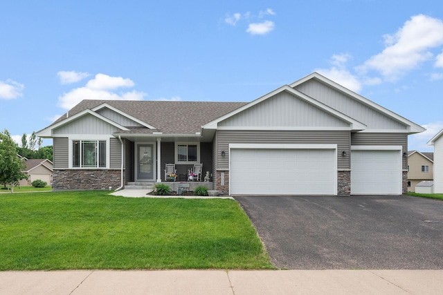17051 Lupine Ln, Big Lake, MN 55309 - view of front of property with stone siding, driveway, an attached garage, a front yard, and a porch
