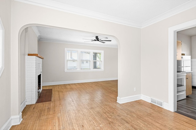 804 20th Ave E, Duluth, MN 55812 - unfurnished living room featuring ornamental molding, a brick fireplace, wood finished floors, ceiling fan, and baseboards