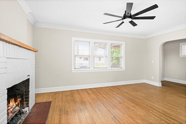804 20th Ave E, Duluth, MN 55812 - unfurnished living room with a brick fireplace, light wood-type flooring, a ceiling fan, ornamental molding, and arched walkways