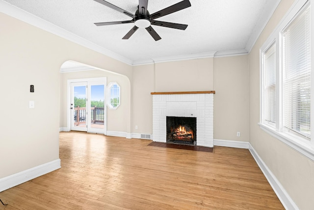 804 20th Ave E, Duluth, MN 55812 - unfurnished living room with a brick fireplace, light wood finished floors, ornamental molding, ceiling fan, and baseboards