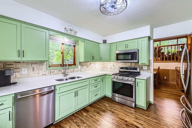 5959 373rd St, North Branch, MN 55056 - kitchen featuring stainless steel appliances, green cabinetry, decorative backsplash, dark wood-type flooring, and a textured ceiling