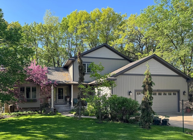 1110 Partridge Ln, North Hudson, WI 54016 - view of front facade featuring a garage, a front lawn, driveway, and stone siding