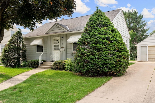 1306 6th Ave NW, Austin, MN 55912 - bungalow-style home with a shingled roof, a front lawn, and a garage