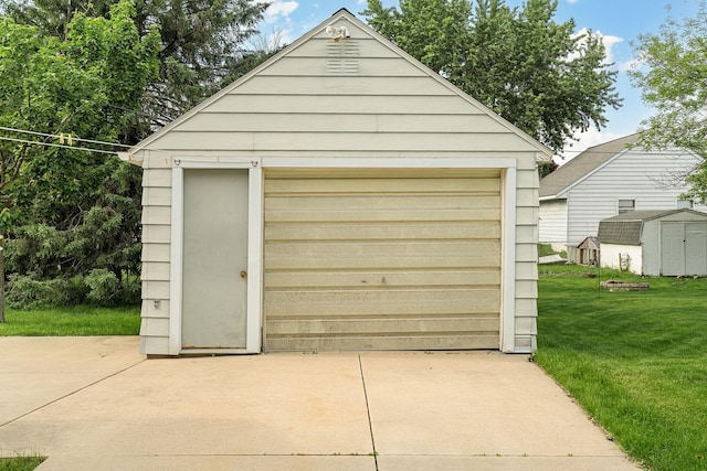 1306 6th Ave NW, Austin, MN 55912 - detached garage featuring concrete driveway and a storage unit