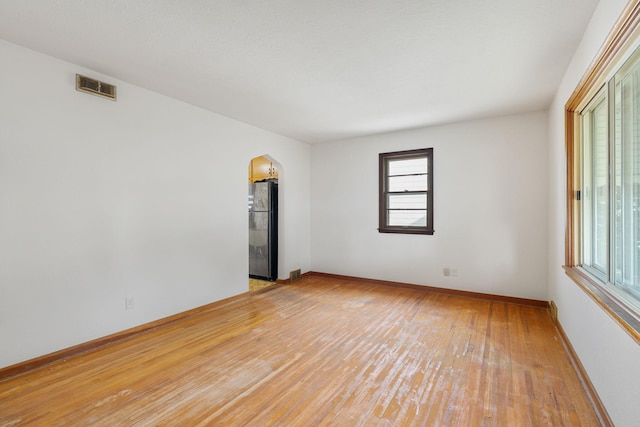 1306 6th Ave NW, Austin, MN 55912 - empty room with arched walkways and light wood-type flooring