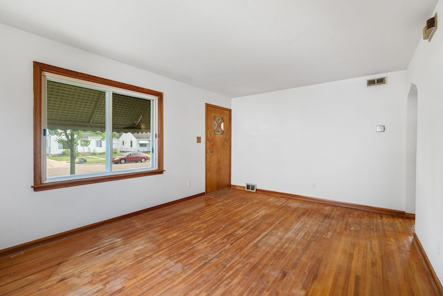 1306 6th Ave NW, Austin, MN 55912 - empty room featuring arched walkways and hardwood / wood-style floors