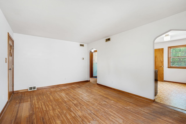 1306 6th Ave NW, Austin, MN 55912 - empty room featuring arched walkways and hardwood / wood-style floors