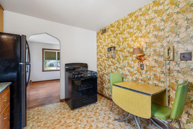 1306 6th Ave NW, Austin, MN 55912 - dining space featuring arched walkways and wallpapered walls
