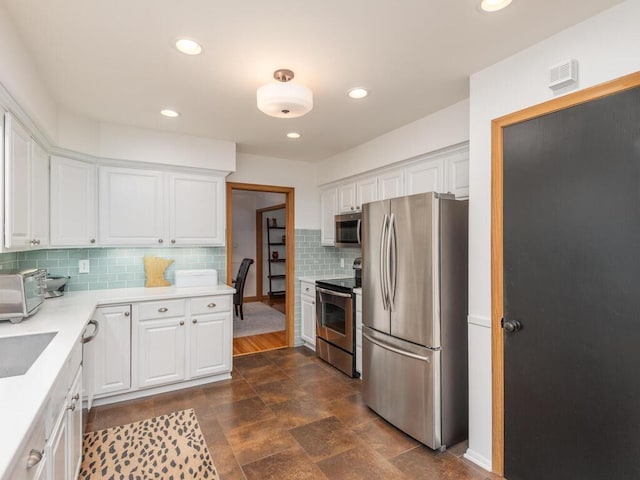 9300 23rd St, Saint Louis Park, MN 55426 - kitchen featuring appliances with stainless steel finishes, white cabinetry, decorative backsplash, light countertops, and recessed lighting