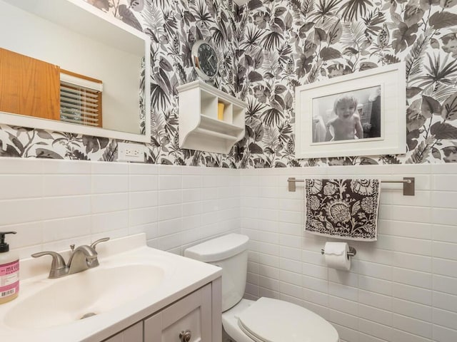 9300 23rd St, Saint Louis Park, MN 55426 - bathroom with wallpapered walls, tile walls, vanity, toilet, and wainscoting