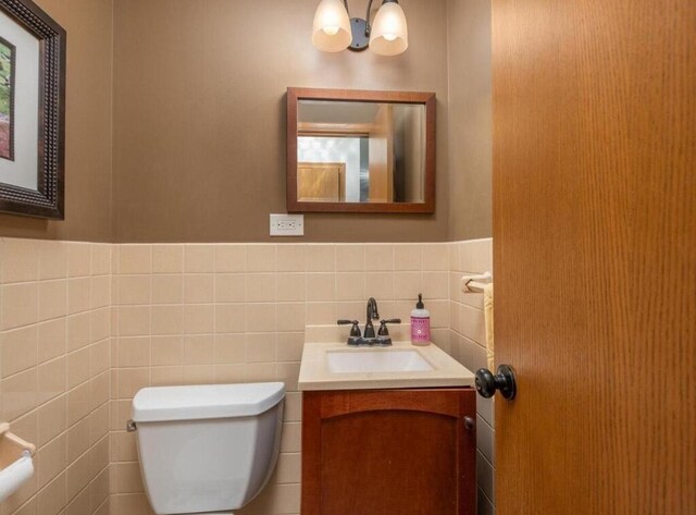 9300 23rd St, Saint Louis Park, MN 55426 - bathroom featuring toilet, vanity, tile walls, and wainscoting