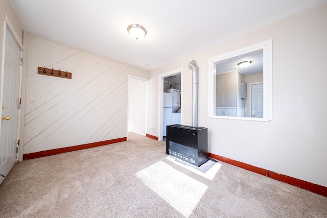 8247 Wentworth Ave S, Bloomington, MN 55420 - unfurnished living room with a wood stove, carpet flooring, baseboards, and wooden walls