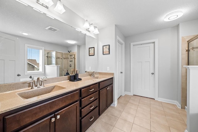 10388 188th St W, Lakeville, MN 55044 - full bathroom featuring a shower stall, a textured ceiling, tile patterned flooring, double vanity, and baseboards