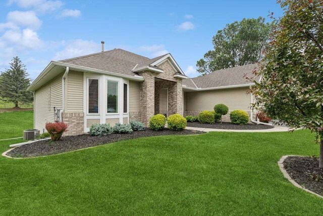 3114 Canyon Cir, Chaska, MN 55318 - view of front facade with a front lawn, a shingled roof, and brick siding