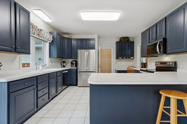 3114 Canyon Cir, Chaska, MN 55318 - kitchen featuring stainless steel appliances, a peninsula, light countertops, and light tile patterned floors