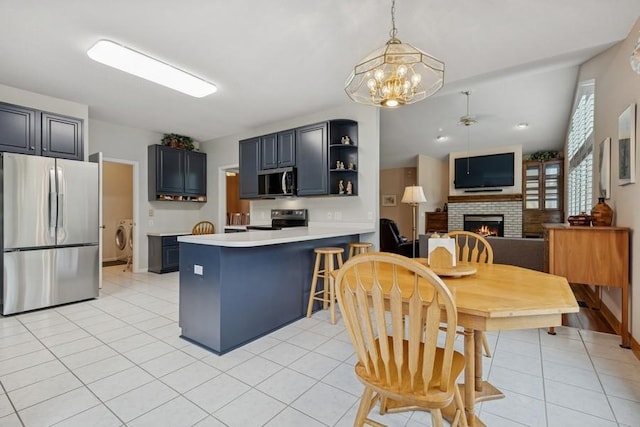 3114 Canyon Cir, Chaska, MN 55318 - kitchen featuring appliances with stainless steel finishes, washer / clothes dryer, a brick fireplace, a chandelier, and light tile patterned floors