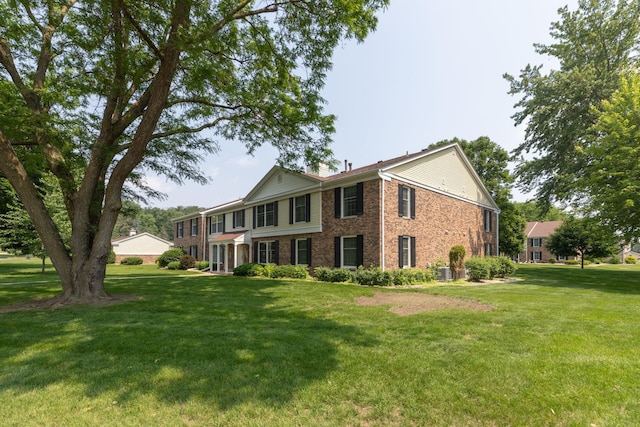 2051 Carriage Dr SW Unit 2051E, Rochester, MN 55902 - view of front facade with brick siding, a front yard, and a chimney