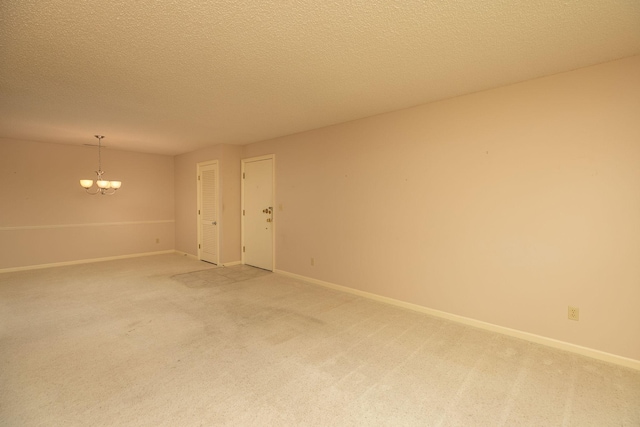 2051 Carriage Dr SW Unit 2051E, Rochester, MN 55902 - spare room with light carpet, a chandelier, and a textured ceiling