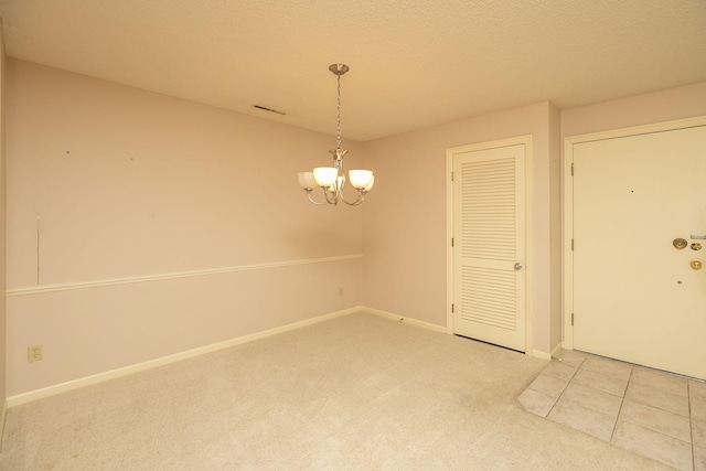 2051 Carriage Dr SW Unit 2051E, Rochester, MN 55902 - unfurnished dining area with light carpet, a chandelier, and a textured ceiling