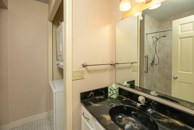 2051 Carriage Dr SW Unit 2051E, Rochester, MN 55902 - bathroom featuring stacked washer / dryer, a tile shower, tile patterned flooring, a textured ceiling, and vanity