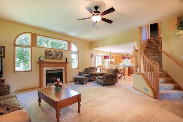 23501 Birch Cir, Rogers, MN 55374 - living area featuring stairs, a ceiling fan, light colored carpet, and a fireplace
