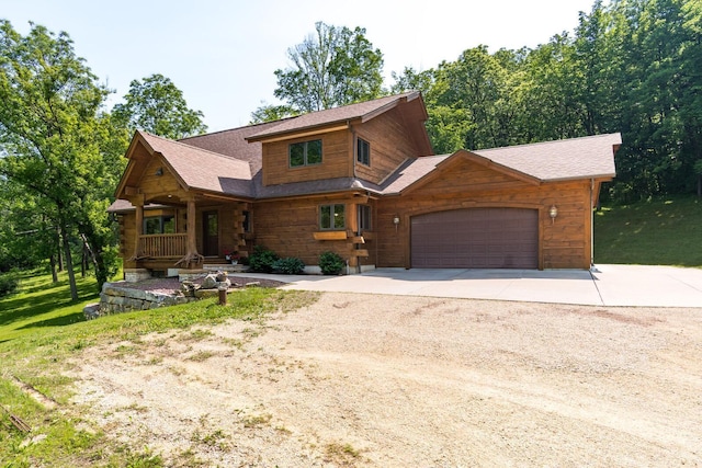 278 Vanity Dr, Shelby Twp, WI 54658 - cabin with driveway, a porch, an attached garage, and roof with shingles