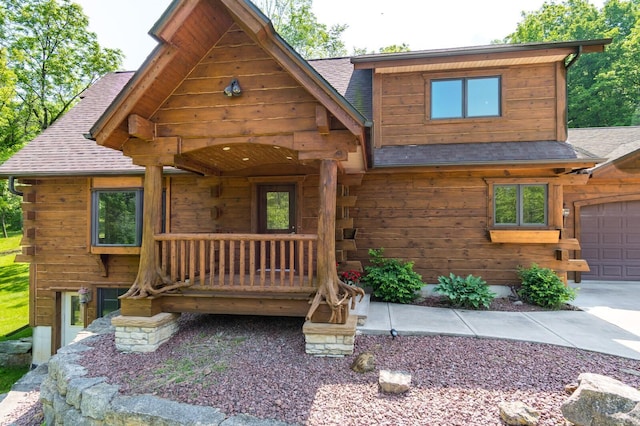 278 Vanity Dr, Shelby Twp, WI 54658 - cabin featuring a shingled roof, a garage, and log siding