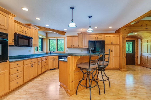 278 Vanity Dr, Shelby Twp, WI 54658 - kitchen featuring black appliances, light wood finished floors, a kitchen bar, recessed lighting, and a center island