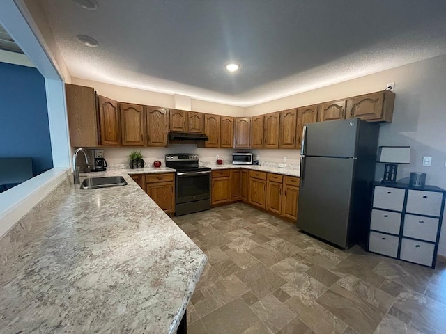 16173 Discovery Cir, Park Rapids, MN 56470 - kitchen featuring appliances with stainless steel finishes, a sink, under cabinet range hood, light countertops, and brown cabinetry