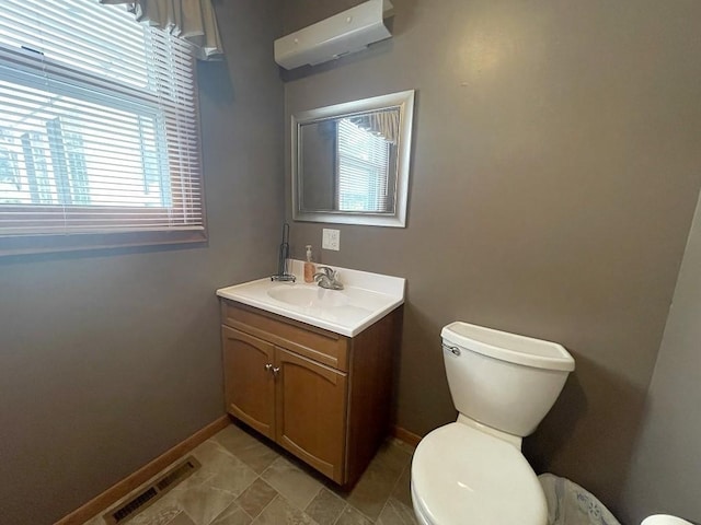 16173 Discovery Cir, Park Rapids, MN 56470 - bathroom with toilet, vanity, baseboards, and a wall unit AC