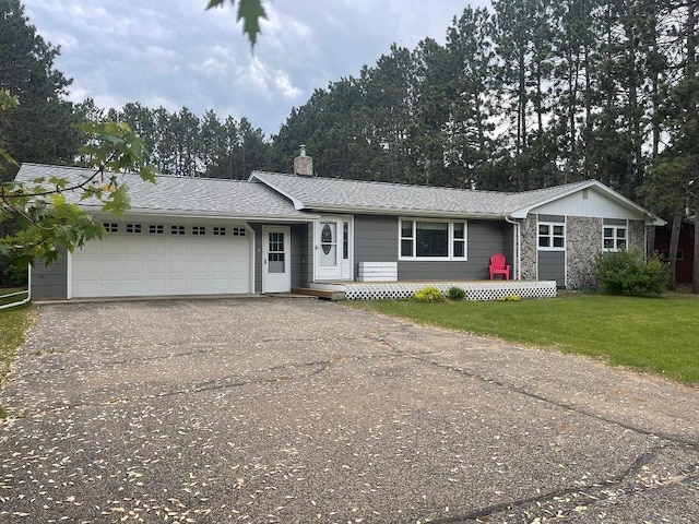 16173 Discovery Cir, Park Rapids, MN 56470 - single story home with asphalt driveway, an attached garage, a chimney, a front lawn, and stone siding