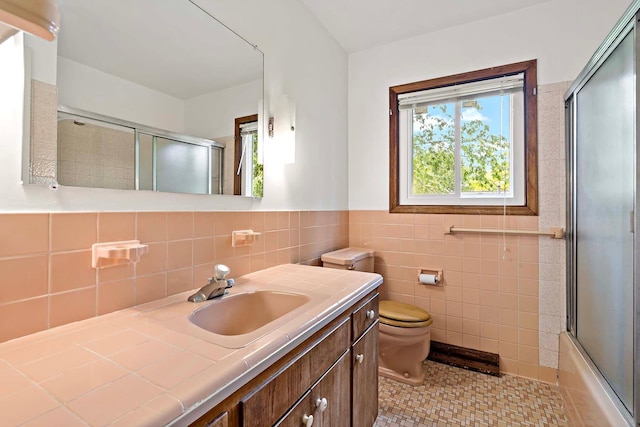 3671 Robinwood Ter, Minnetonka, MN 55305 - bathroom with vanity, toilet, tile walls, tile patterned floors, and shower / bath combination with glass door
