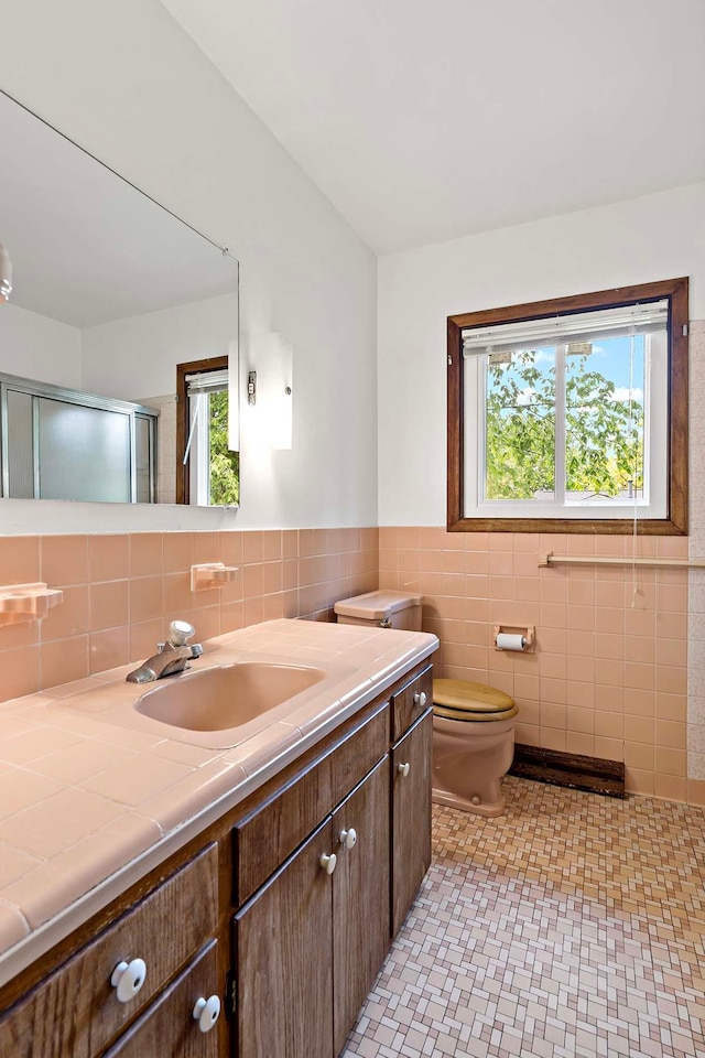 3671 Robinwood Ter, Minnetonka, MN 55305 - full bathroom with vanity, tile walls, toilet, and an enclosed shower