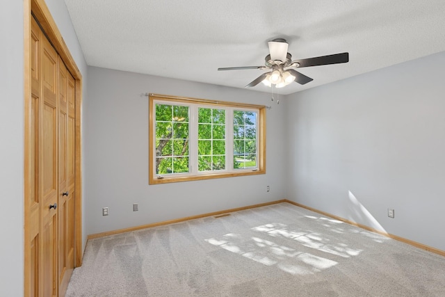 14057 Flintwood Ct, Apple Valley, MN 55124 - unfurnished bedroom with a closet, light carpet, a ceiling fan, and a textured ceiling