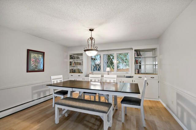 3004 36th Ave NE, Saint Anthony, MN 55418 - dining area featuring a baseboard heating unit, a textured ceiling, and light wood finished floors