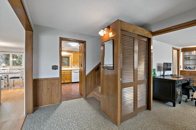 3004 36th Ave NE, Saint Anthony, MN 55418 - corridor with wainscoting, a desk, wood walls, and a textured ceiling