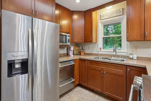 9320 Revere Ln N, Maple Grove, MN 55369 - kitchen with stainless steel appliances, a sink, light countertops, brown cabinetry, and recessed lighting