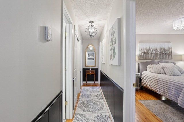 9320 Revere Ln N, Maple Grove, MN 55369 - hallway with a chandelier, a textured ceiling, and light wood finished floors