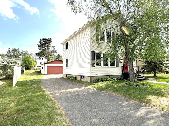 638 James St, Ely, MN 55731 - view of side of property featuring an outbuilding, a detached garage, and a lawn