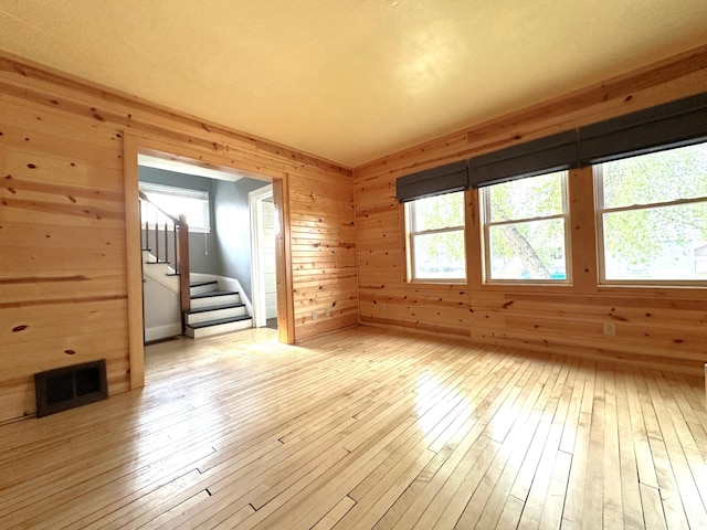 638 James St, Ely, MN 55731 - unfurnished room with stairs, light wood-style floors, and wood walls