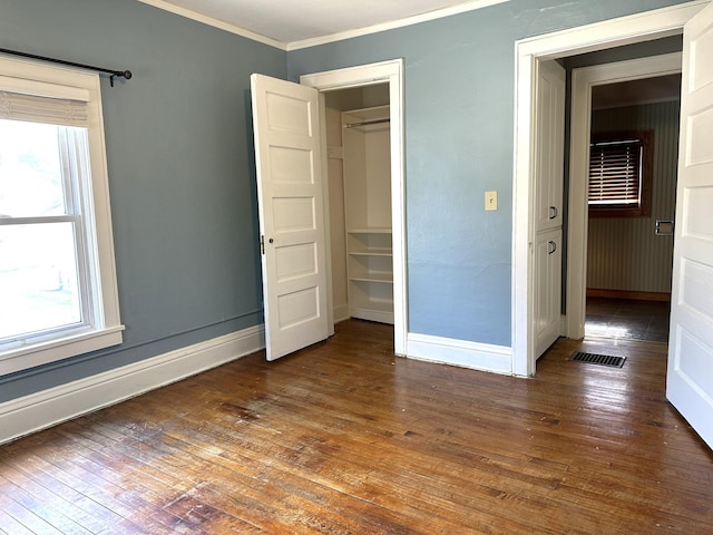638 James St, Ely, MN 55731 - unfurnished bedroom featuring ornamental molding, baseboards, hardwood / wood-style floors, and a closet