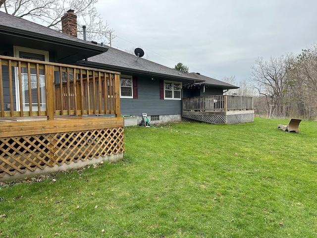 332 Pleasant Ave, Ellsworth, WI 54011 - back of property featuring a deck, a shingled roof, a yard, and a chimney